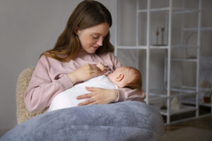 A new mom gearing up for breastfeeding to her baby in a comfortable setting, showcasing a nurturing bond and essential breastfeeding techniques.